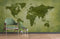 Papier peint mural Carte du Monde Verte avec fauteuil en velours vert et bois pour une touche d’évasion