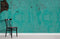 Chaise noire en bois avec dossier à lattes, dans papier peint mural turquoise corrodé