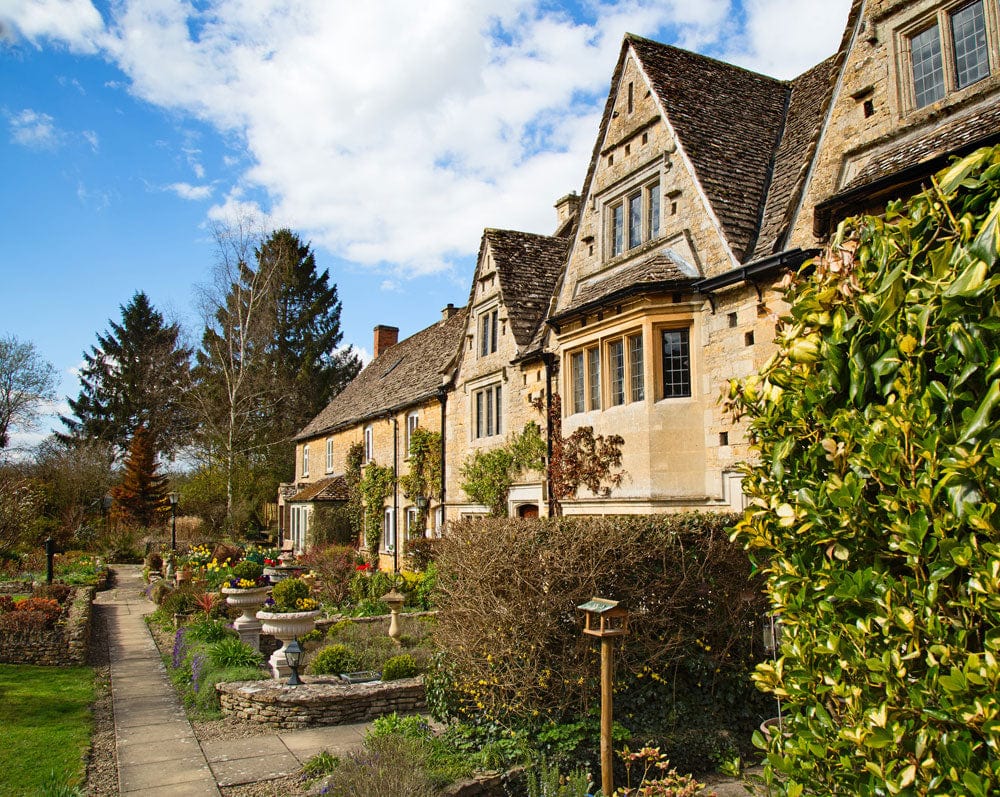 Murale de Papier Peint Ville Florale montrant maisons en pierre avec jardins et chemin pavé