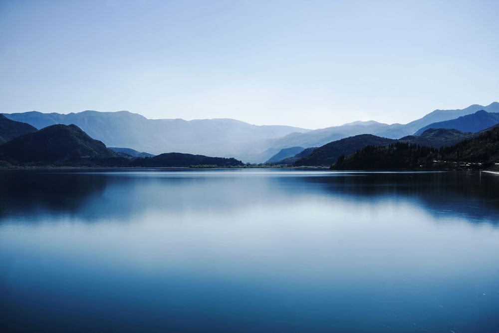 Murale de paysage lacustre bleu gélatineux avec lac tranquille et montagnes reflétées