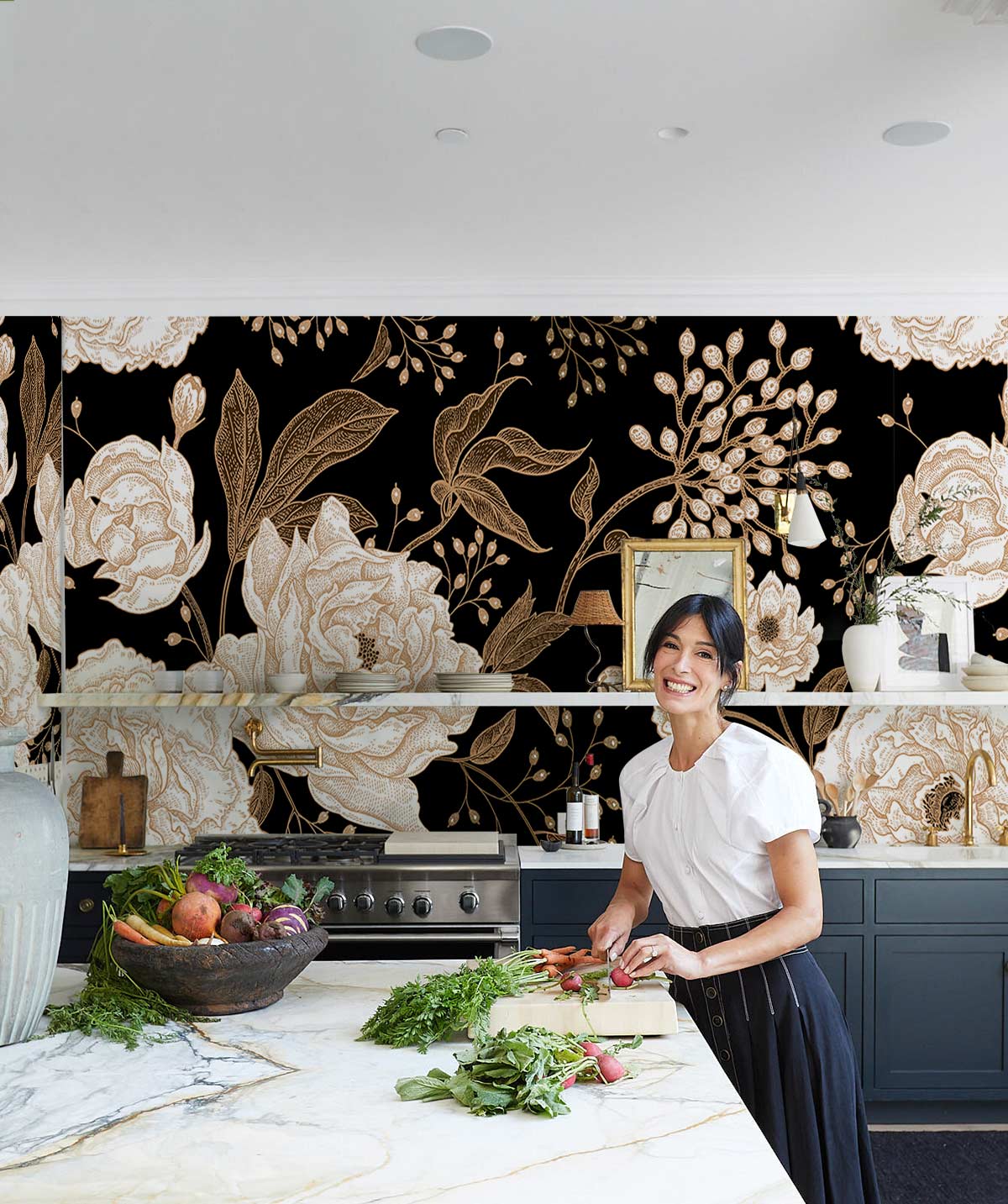 Femme préparant des légumes dans une cuisine élégante avec un papier peint floral