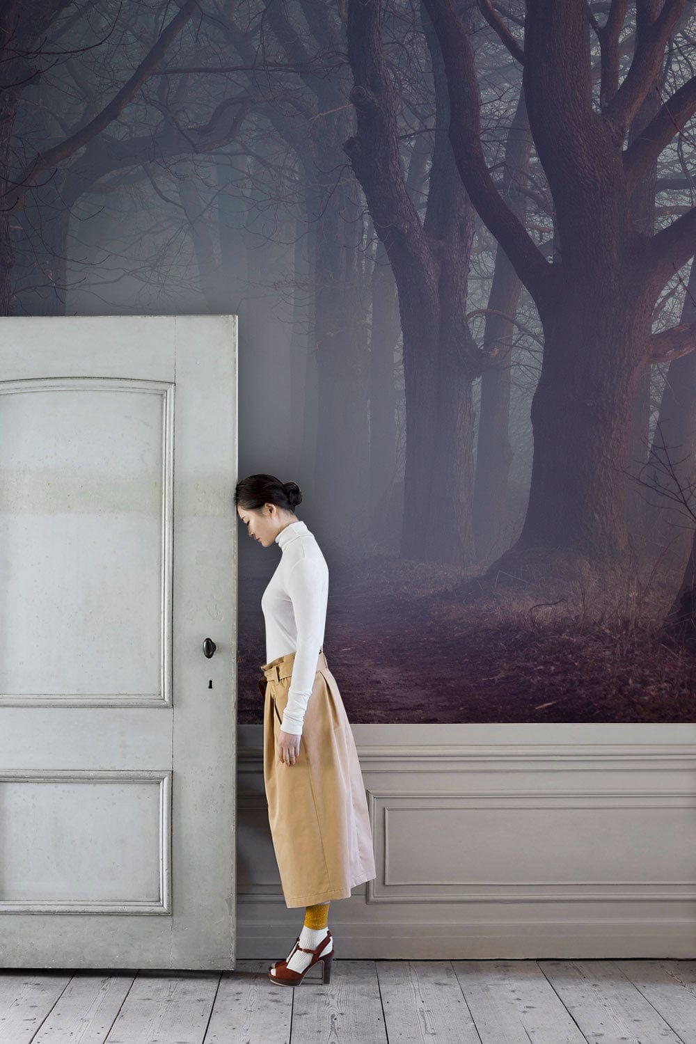 Femme en turtleneck blanc et jupe beige avec papier peint panoramique halo de brouillard