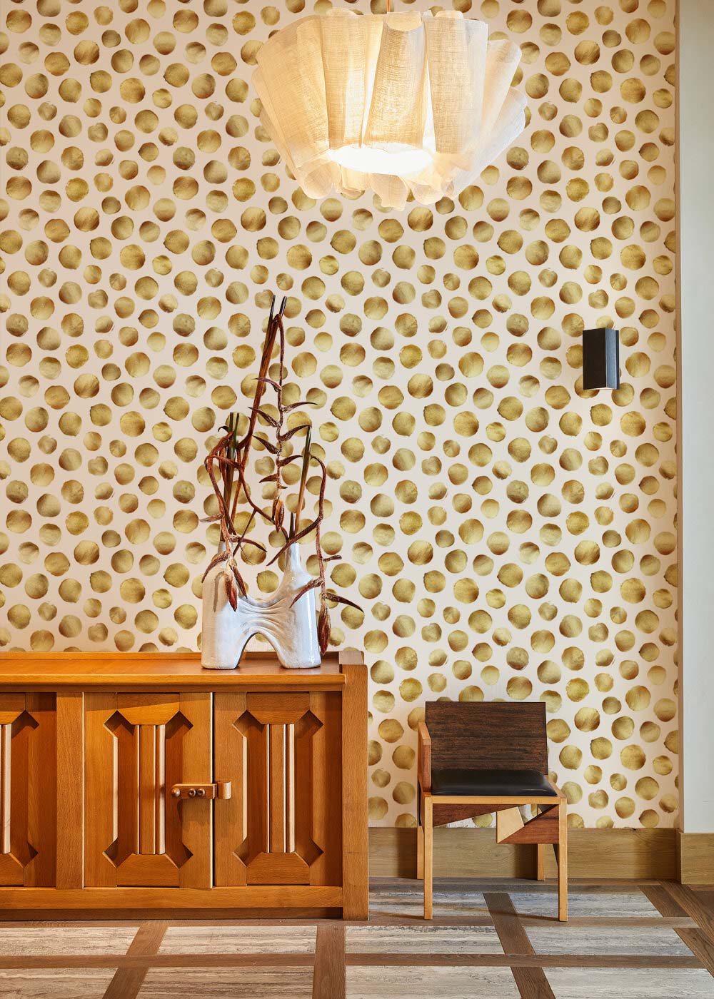 Papier peint mural à pois dorés avec cabinet en bois et panneau décoratif, touche d’élégance