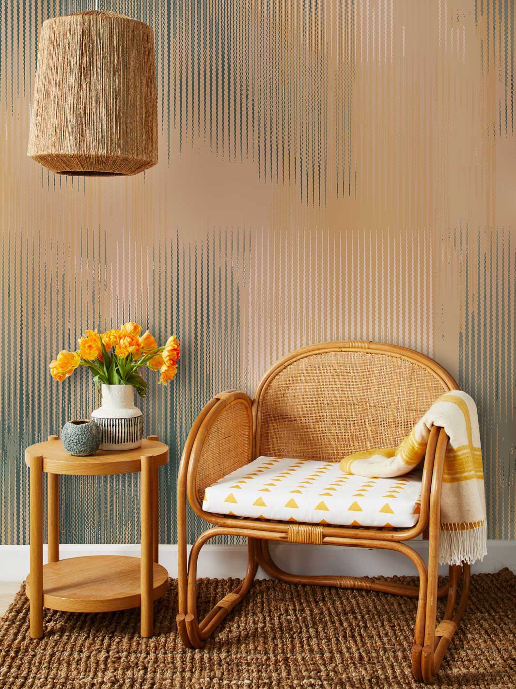 Chaise en rotin tissée avec coussin blanc à triangles jaunes, idéal pour un papier peint mural à rayures brumeuses