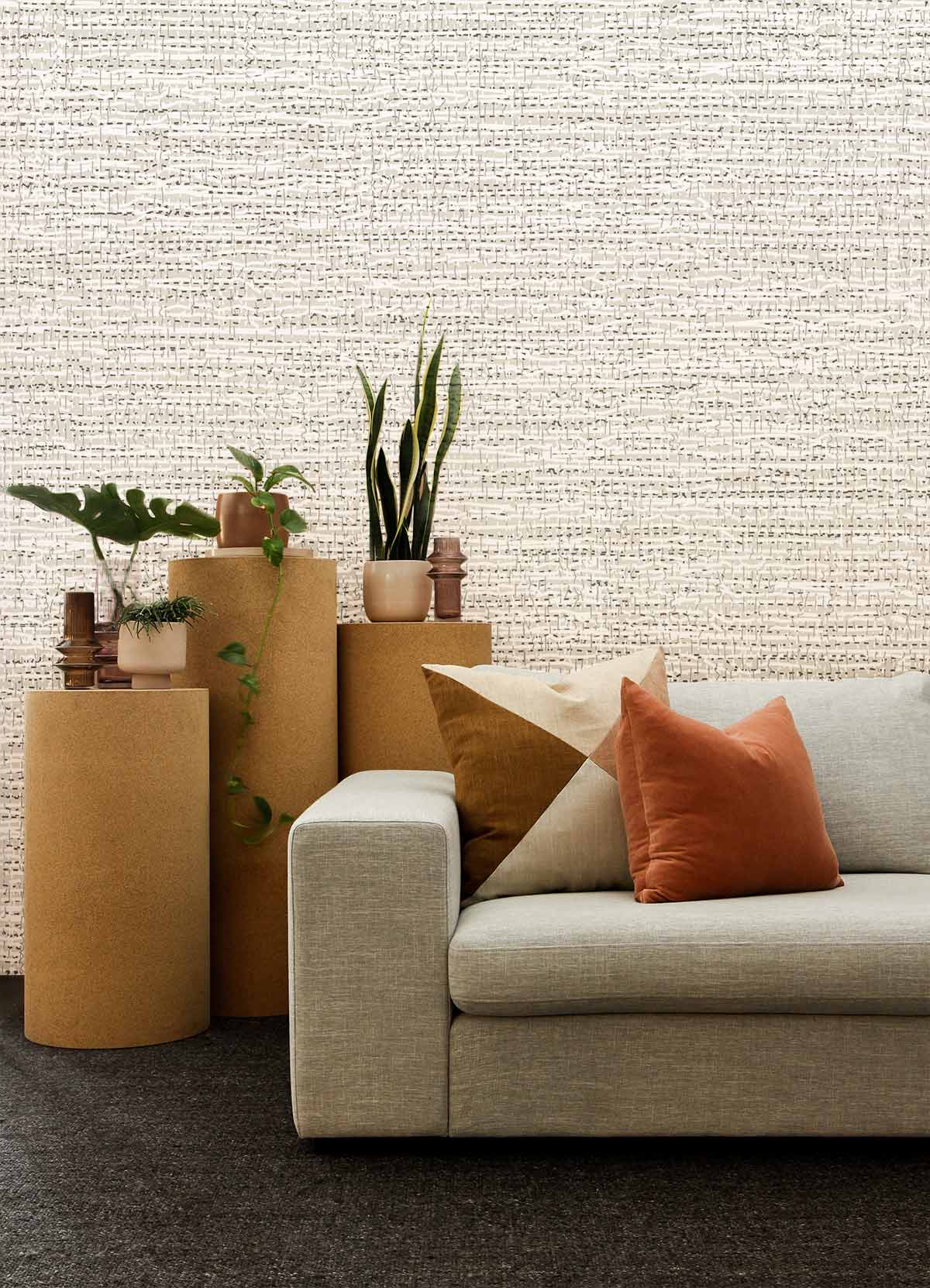 Canapé en tissu beige clair avec coussins, idéal pour un papier peint mural à texture sale
