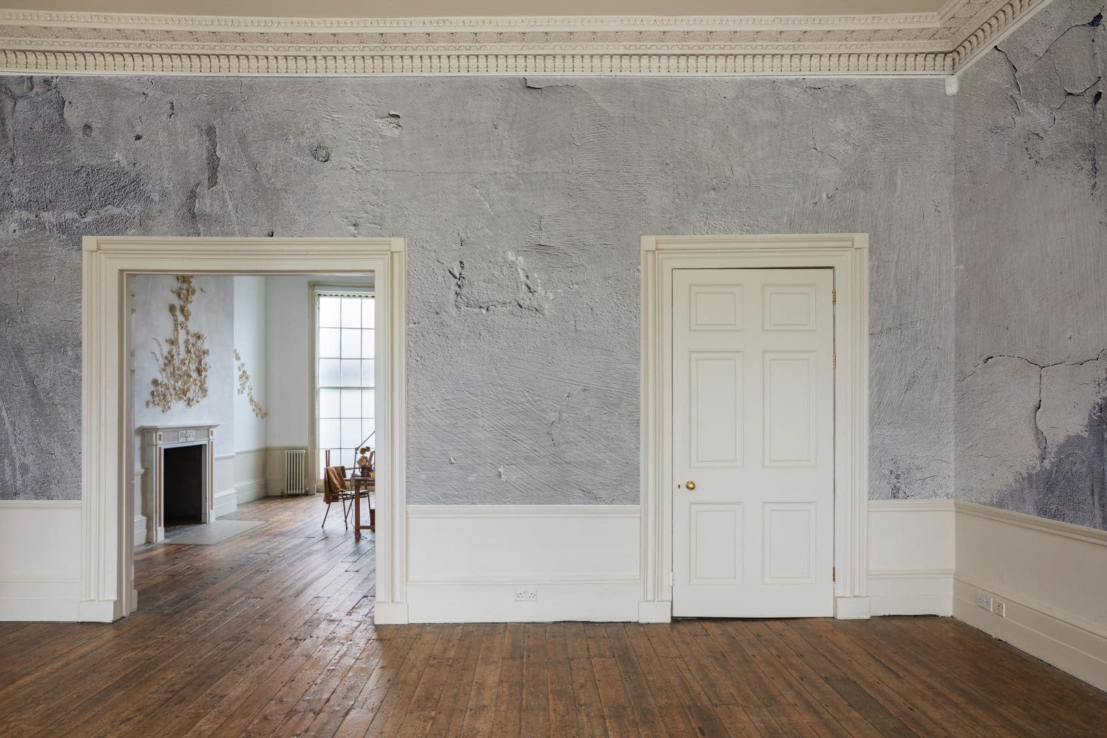 Photo d’un mur blanc moucheté en papier peint mural dans une pièce vide avec plancher en bois