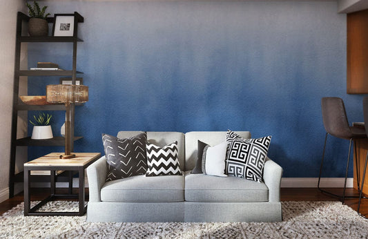 Canapé deux places gris clair avec coussins décoratifs, idéal pour peinture murale mural bleu brumeux