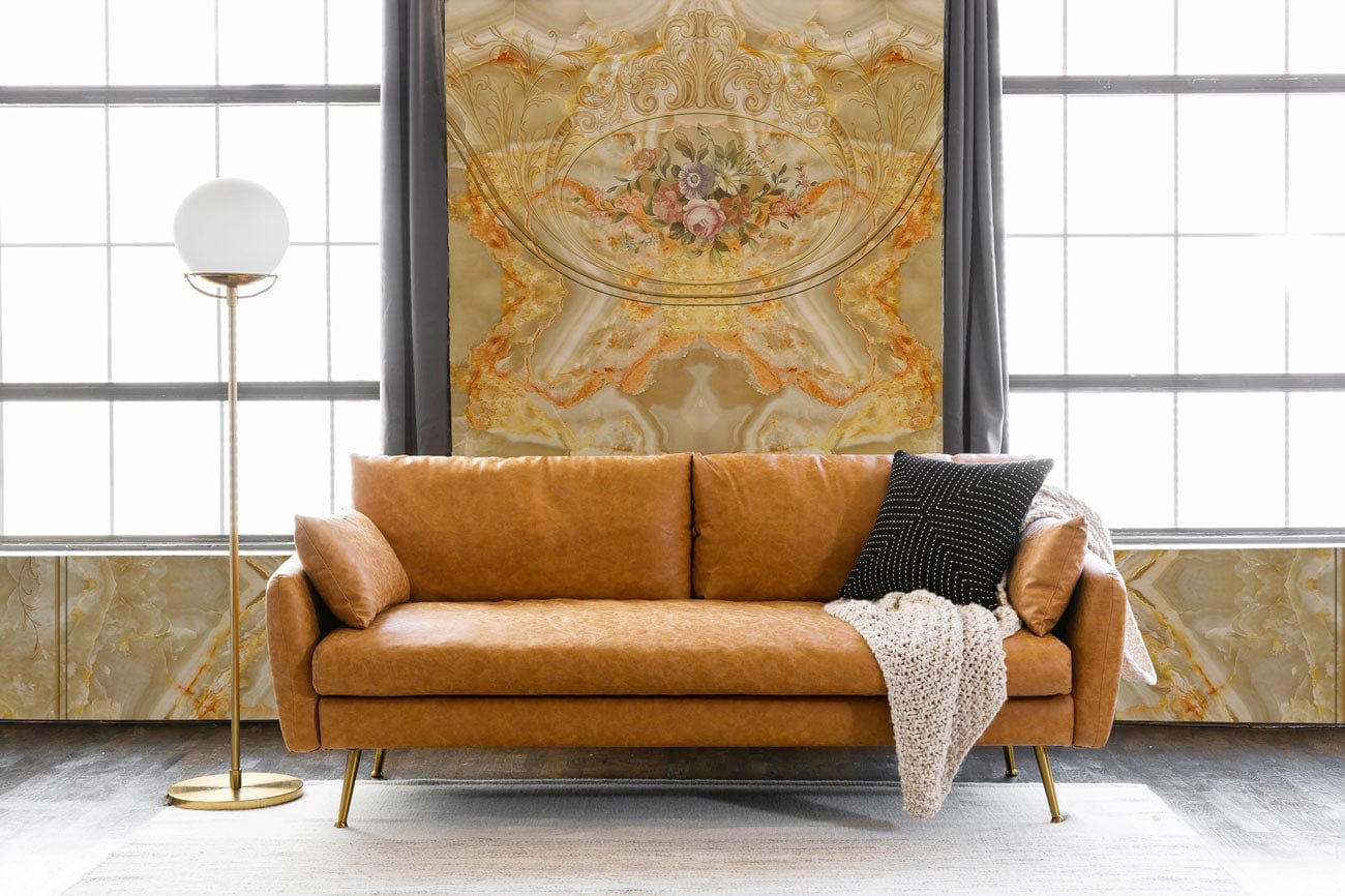 Canapé en cuir marron avec pieds en or et couverture, parfait pour un cadre royal dans un peint mural