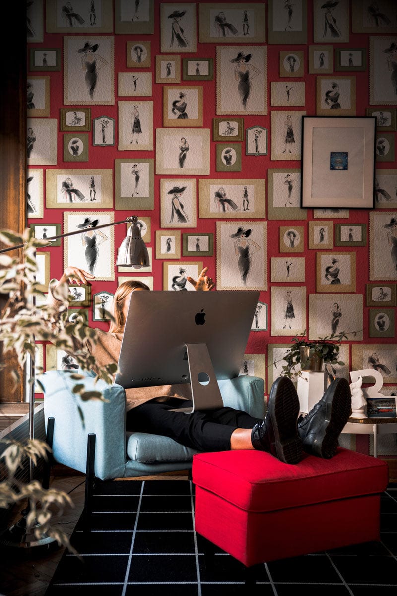 Person travaillant sur un ordinateur dans une pièce cosy avec papier peint mural Dame Moderne