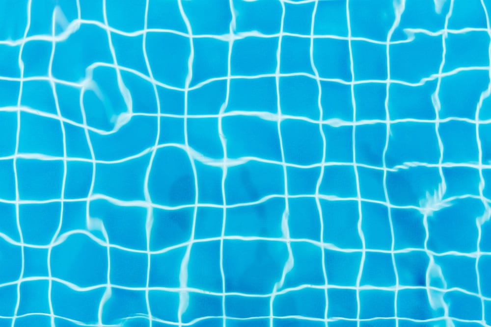 Papier peint mural de piscine claire avec eau bleue et motif de carreaux lumineux