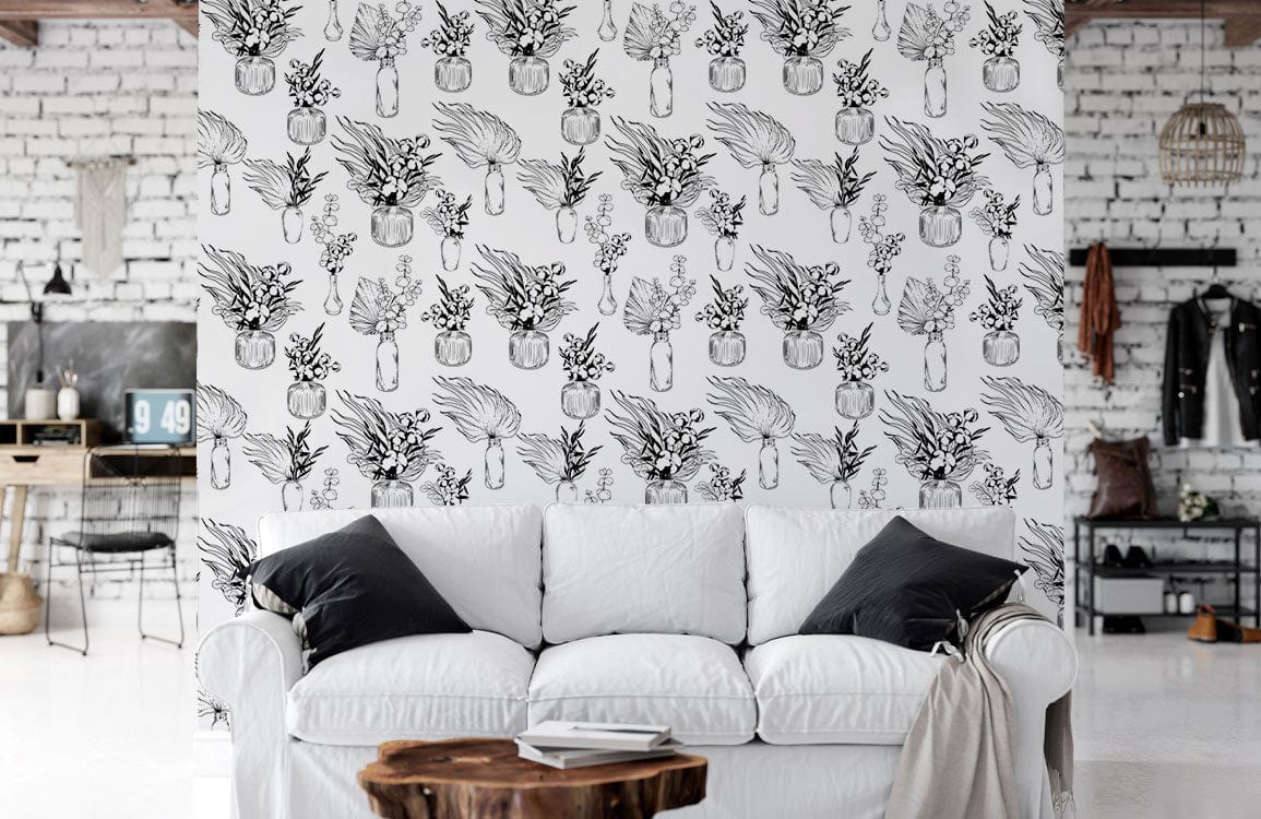 Sofa blanc avec coussins noirs devant un papier peint mural de vases répétitifs