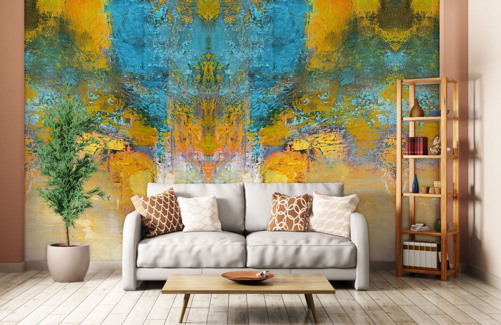 Canapé deux places gris clair avec coussins décoratifs, idéal pour un papier peint mural doré et bleu