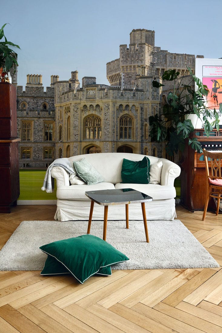 Sofa blanc avec coussins verts devant un papier peint mural du Château de Windsor