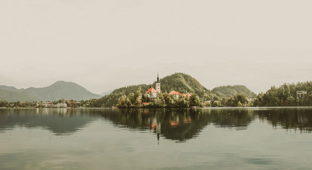Papier peint mural Église sur le lac avec montagnes et arbres, décoration naturelle