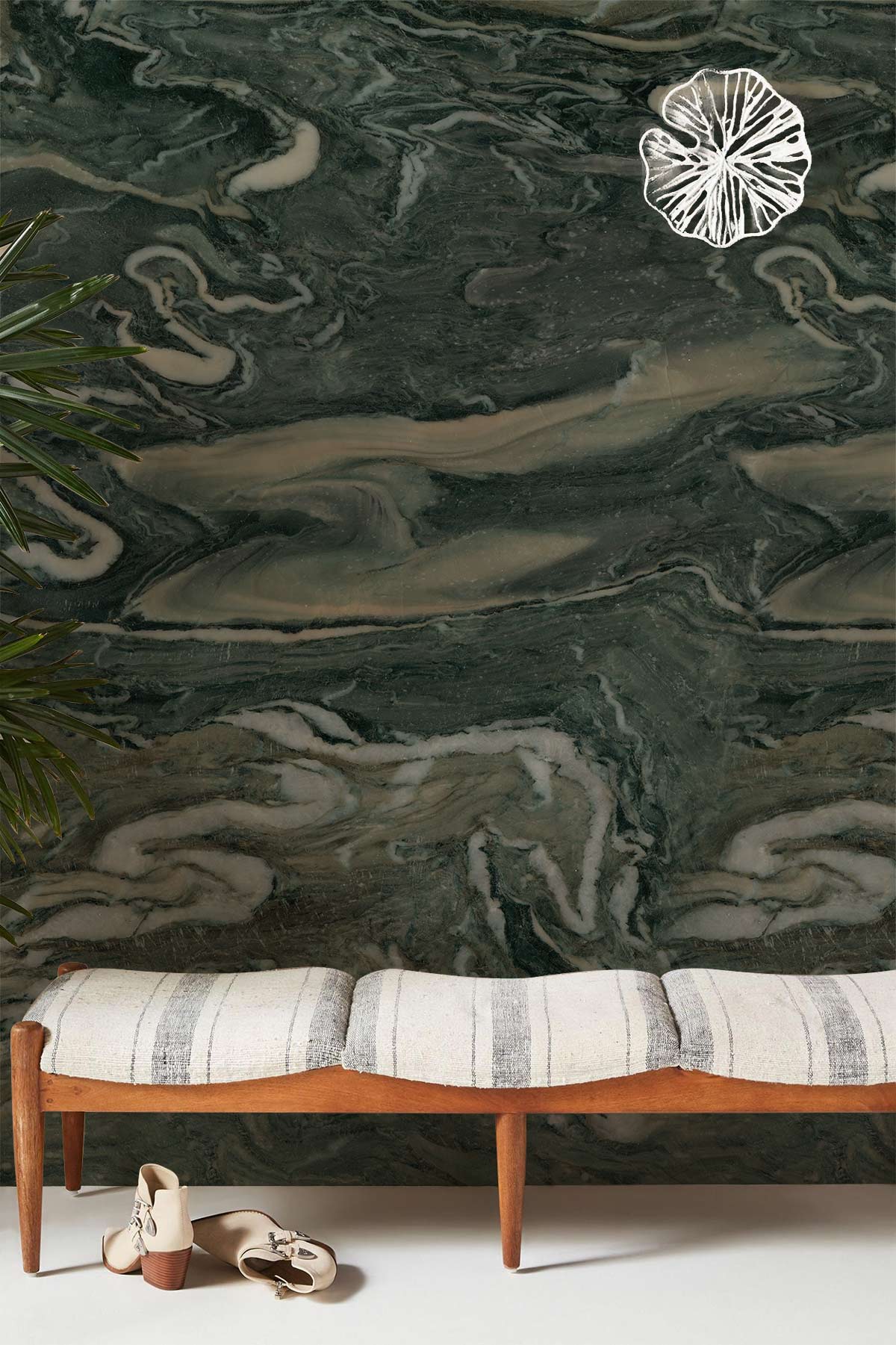 Image d’une banquette en bois avec coussins rayés, adaptée au papier peint mural en marbre vert foncé