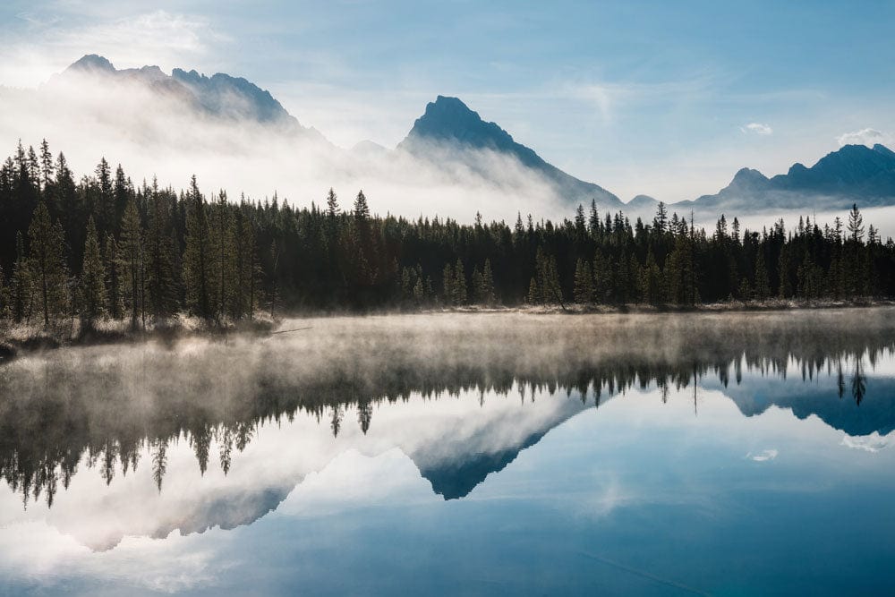 Peint mural montagnes avec lac tranquille, forêt de pins et sommets brumeux