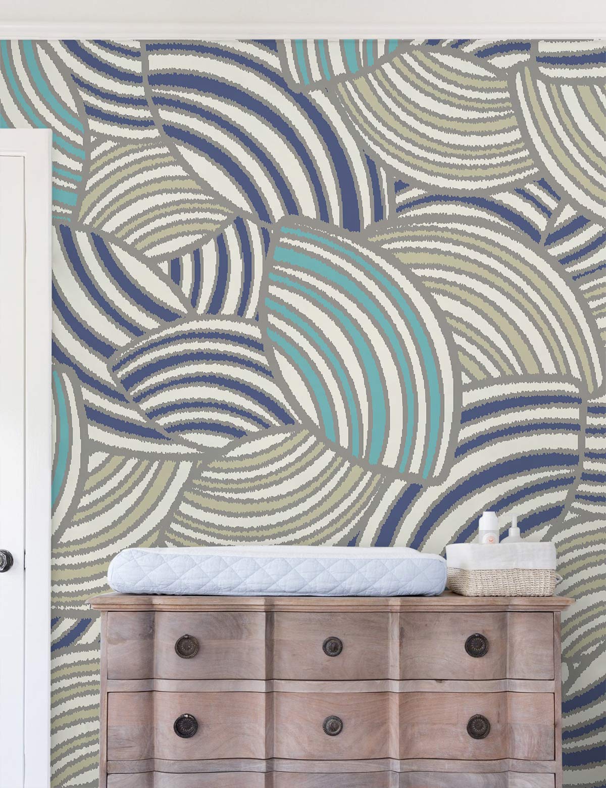 Dresser de nursery avec tapis à langer devant un papier peint mural motif coquillages