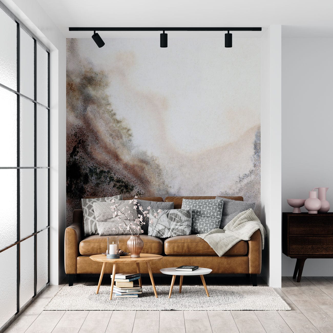 Sofa en cuir tan avec coussins et couverture, dans un décor avec mural mur infecté
