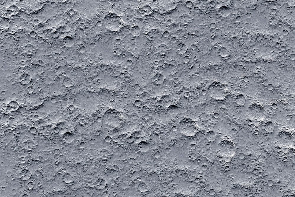 Papier peint mural nids-de-poule avec surface gravée et texture grise monochrome