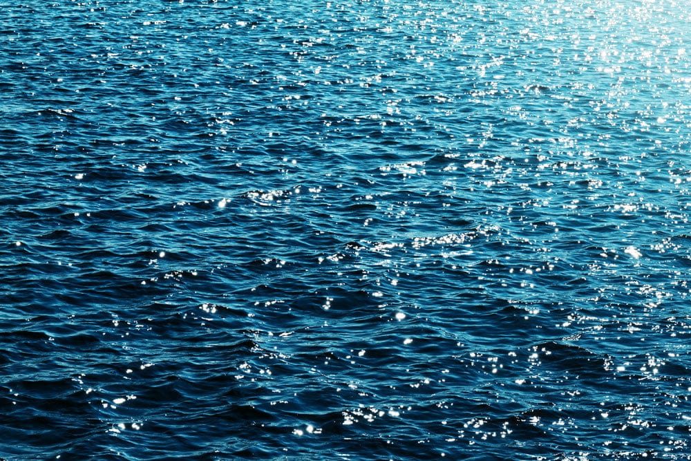 Papier peint mural océan avec vagues bleues scintillantes pour une décoration marine