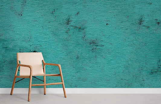 Chaise moderne en bois clair avec siège en toile ou cuir, dans un décor mural peinture corrodée turquoise