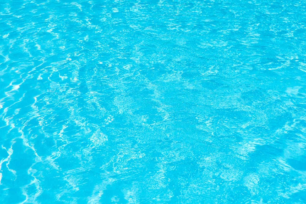 Papier peint mural piscine avec eau bleue claire et ondulations pour décoration intérieure