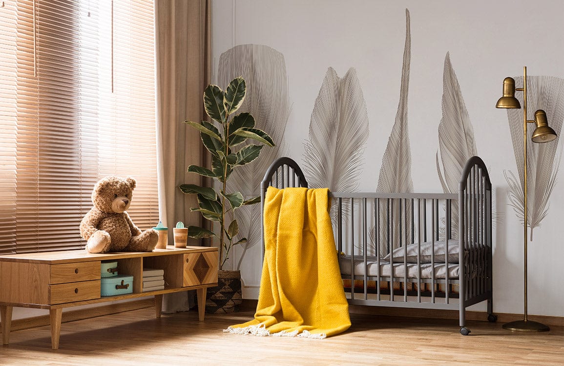Crib gris en bois avec couverture jaune, dans un décor avec papier peint mural Plumes Différentes