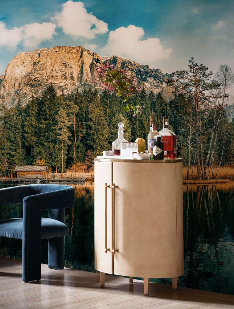 Cabinet en bois crème avec poignées en laiton et bouteille de liquor sur un papier peint mural réflexion