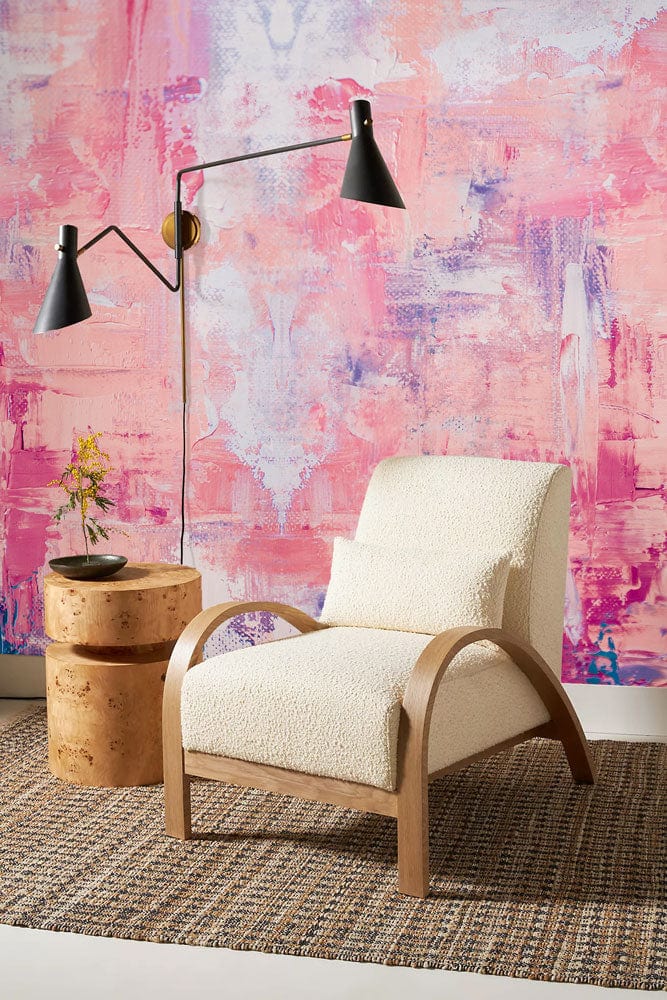 Chaise en boucle crème avec bras en bois clair, parfait pour un murale rose rêveur