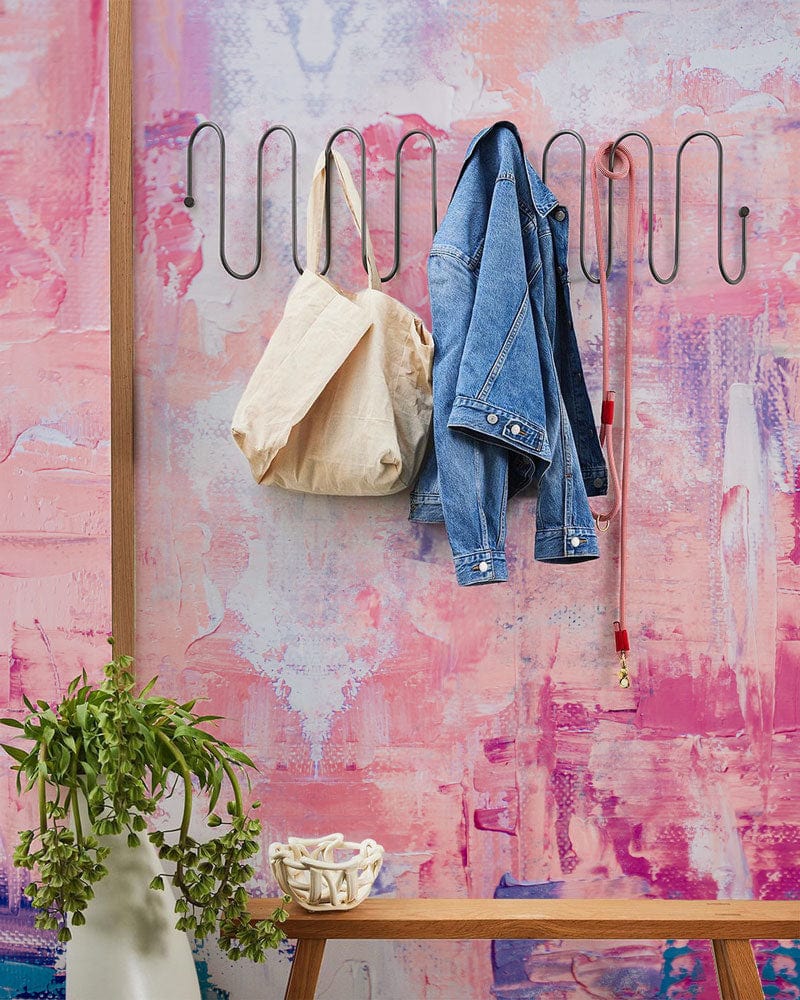 Porte-manteaux noir ondulé en métal avec papier peint mural rose rêveur décoration intérieure