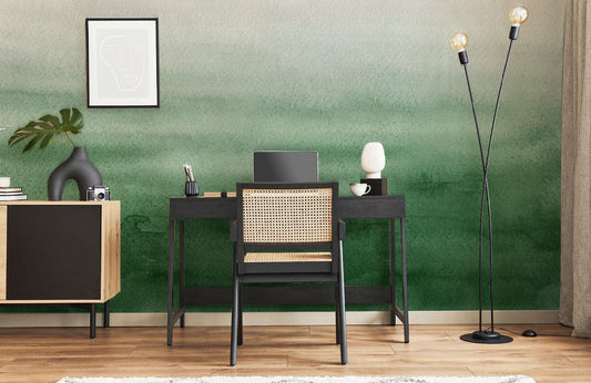 Image d’un bureau noir avec chaise en rotin, montrant un papier peint mural texture aquarelle verte