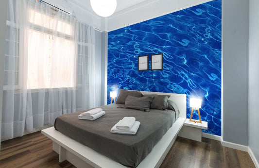 Papier peint mural vagues avec un lit moderne en drap gris foncé et serviettes blanches